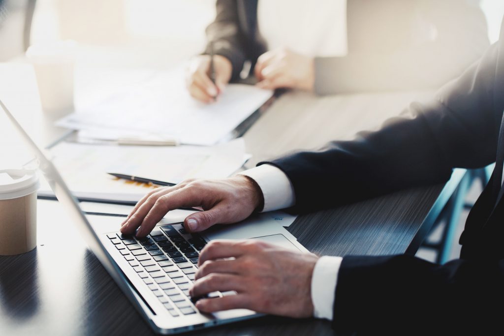 Businessman works with a laptop in office Person filling in a form on a laptop