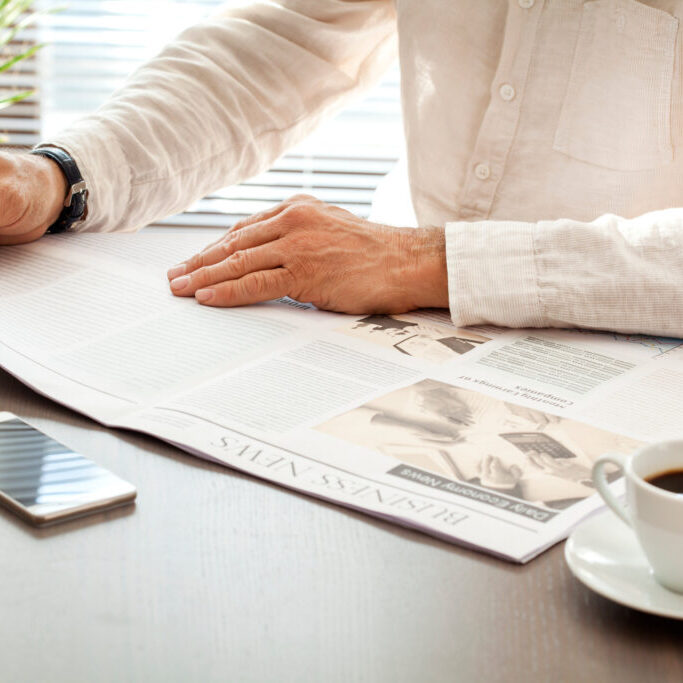 Man reading newspaper on table Man reading newspaper on table